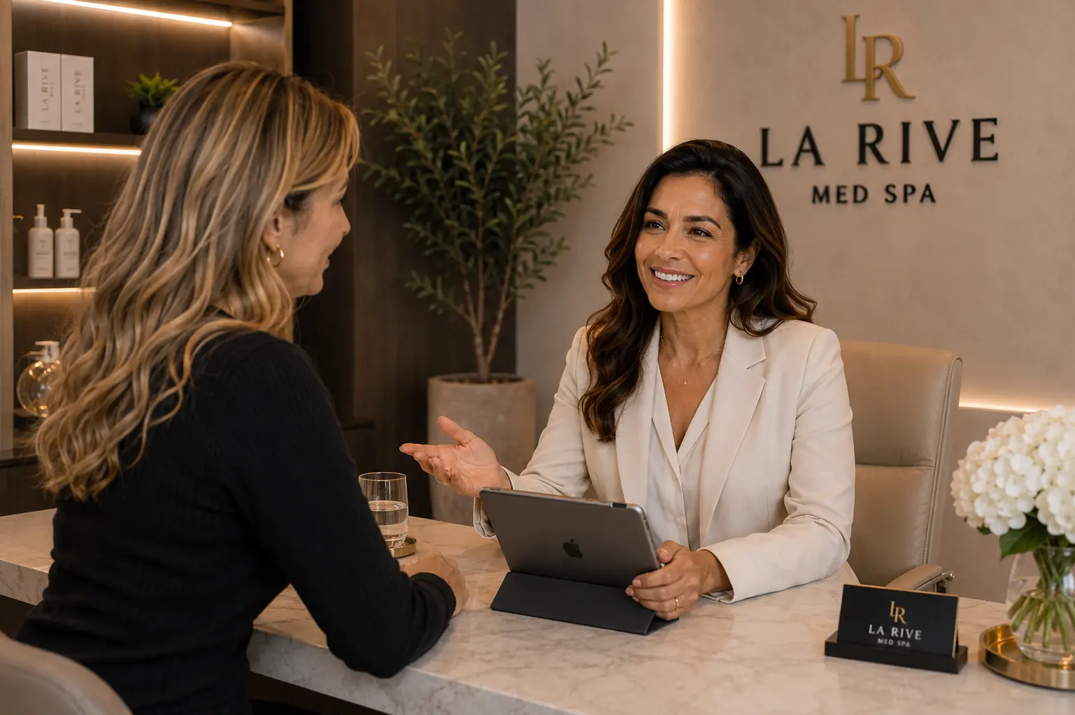 A clinician in conversation with a client across the consultation desk at La Rive Med Spa