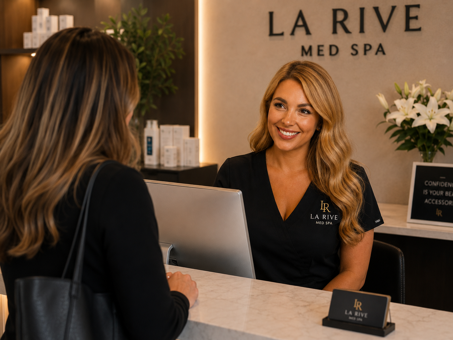 A team member welcoming a client at the reception desk at La Rive Med Spa